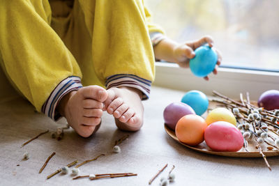 Low section of girl playing with easter eggs at home