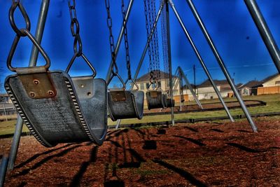 Close-up of swings in playground on sunny day