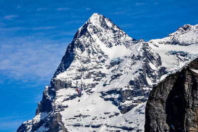 Scenic view of snowcapped mountains against sky and skydiving