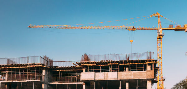 Low angle view of crane against clear sky