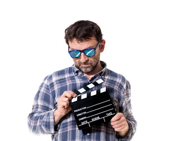 Mid adult man holding camera over white background