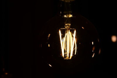 Close-up of illuminated light bulb in the dark