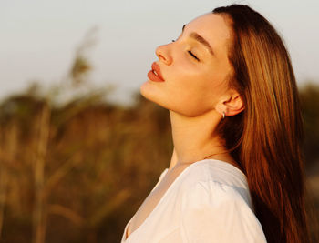 Close-up portrait of young woman with eyes closed