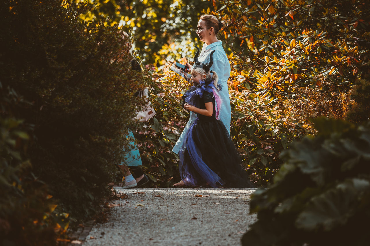 WOMAN STANDING BY TREE