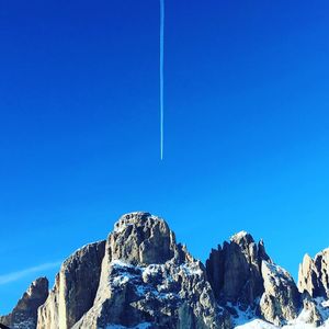 Low angle view of vapor trail against clear blue sky