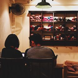 Rear view of people sitting on table