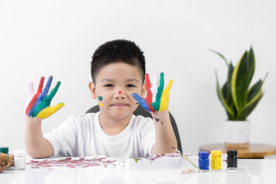 Portrait of cute boy holding table