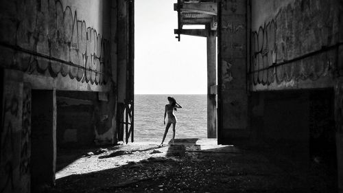 Full length of woman standing at beach against sky