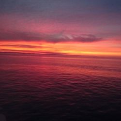 Scenic view of sea against dramatic sky during sunset