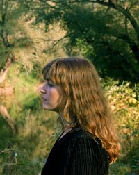 Profile view of woman against trees