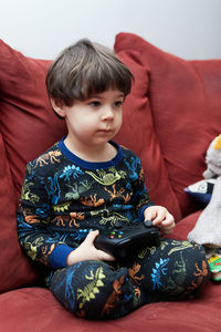 Portrait of girl sitting on sofa at home