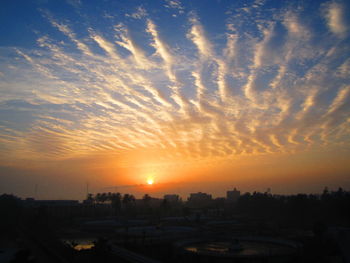 Silhouette cityscape against sky during sunset