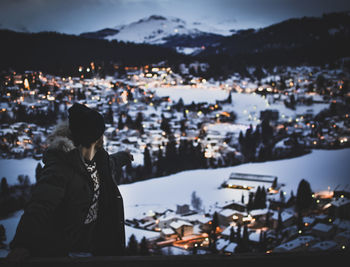 Man against illuminated cityscape during winter