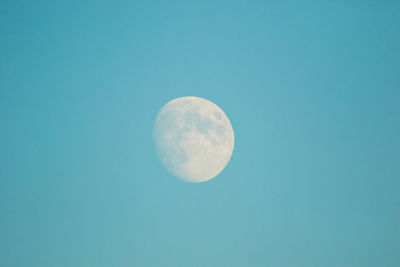 Low angle view of moon against blue sky