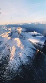 Aerial view of snowcapped mountains against sky during winter