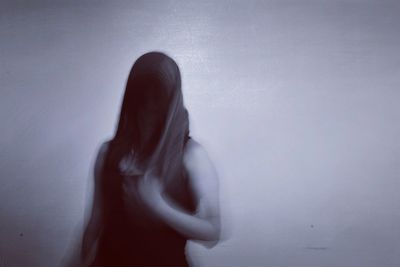 Blurred motion of person standing against wall