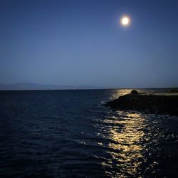 Scenic view of sea against clear sky at night