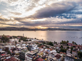 High angle view of city by sea against sky