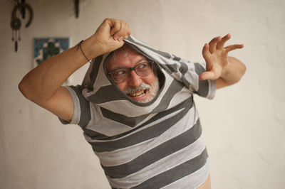 Portrait of man wearing hat standing against wall