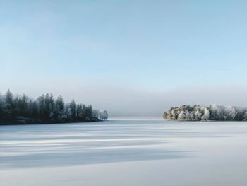 Scenic view of lake against clear sky during winter