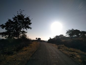 Road amidst trees against sky