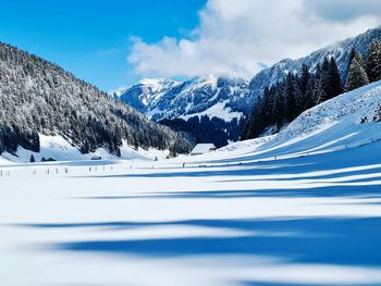 Scenic view of snow covered mountains against sky