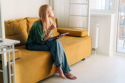 Freelancer woman working from home using an electronic tablet.