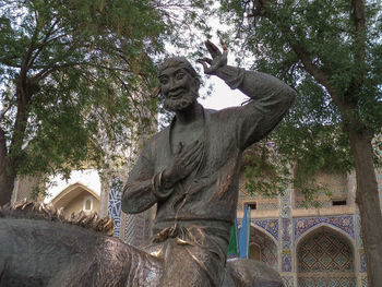 Low angle view of statue against trees