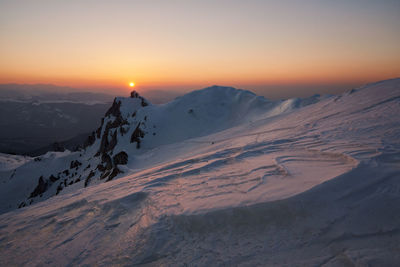 Scenic view of snowcapped mountains against sky during sunset