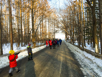 Rear view of people walking in snow