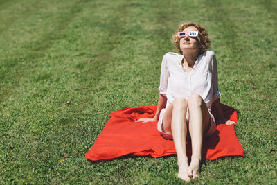 Portrait of young woman sitting on grass