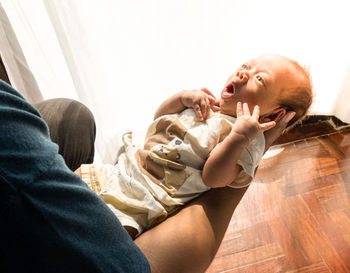 Midsection of father with baby at home