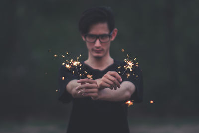 Young man holding sparklers