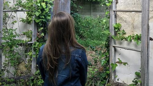 Rear view of woman standing against plants