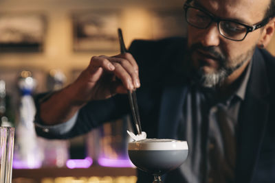 Male bartender preparing cocktail at bar counter