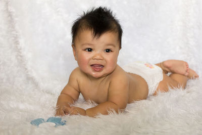 Portrait of cute baby lying on bed