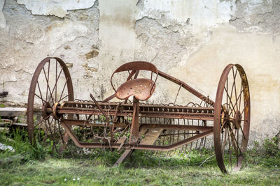 Old abandoned shopping cart against wall