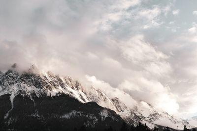 Low angle view of snowcapped mountains against sky