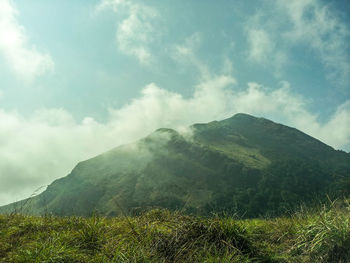 Scenic view of mountains against cloudy sky