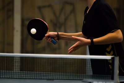 Midsection of woman playing table tennis