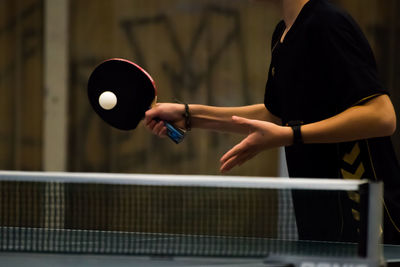 Midsection of man playing table tennis