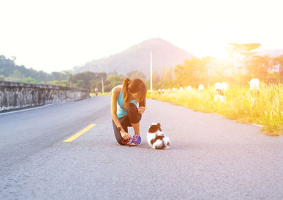 Full length of woman with dog on road