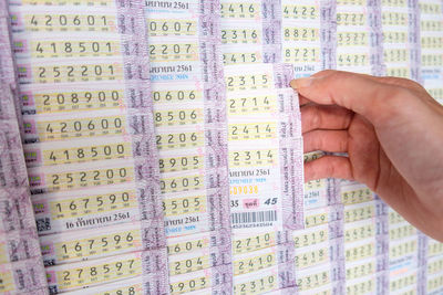 High angle view of hand holding lottery tickets