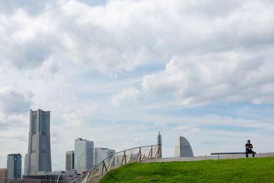 Buildings in city against cloudy sky