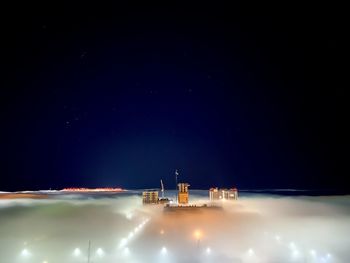 Illuminated cityscape against sky at night