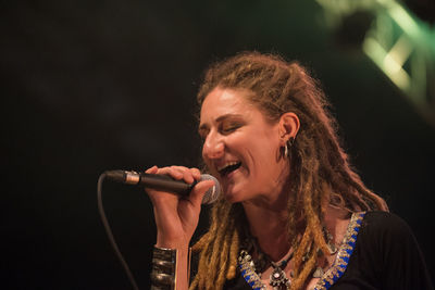 Portrait of a smiling young woman holding camera