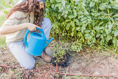 High angle view of young woman watering plants