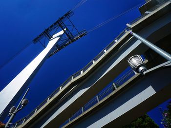 Low angle view of pedestrian ramps against clear blue sky