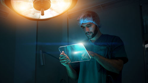 Midsection of man holding illuminated light