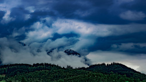 Panoramic view of land and trees against sky